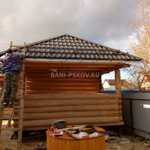 Баня с вальмовой крышей и рубленной в лапу юбкой